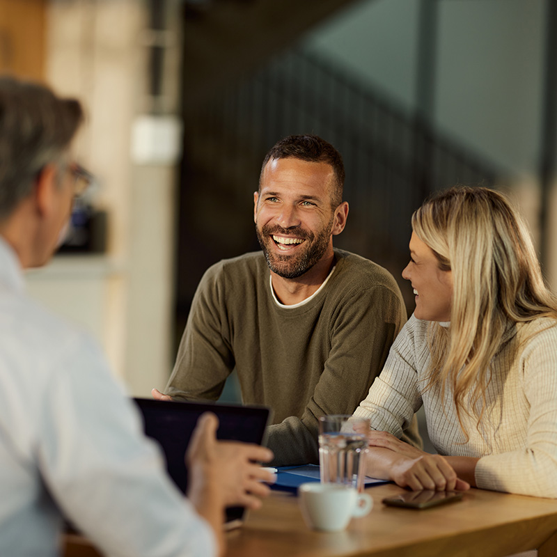 Happy couple talking to their realtor agent on a meeting