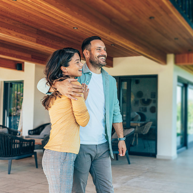 Couple standing in front of their new home