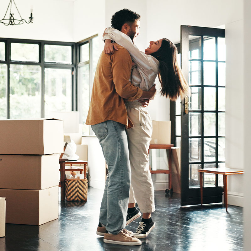 Happy couple with boxes in living room